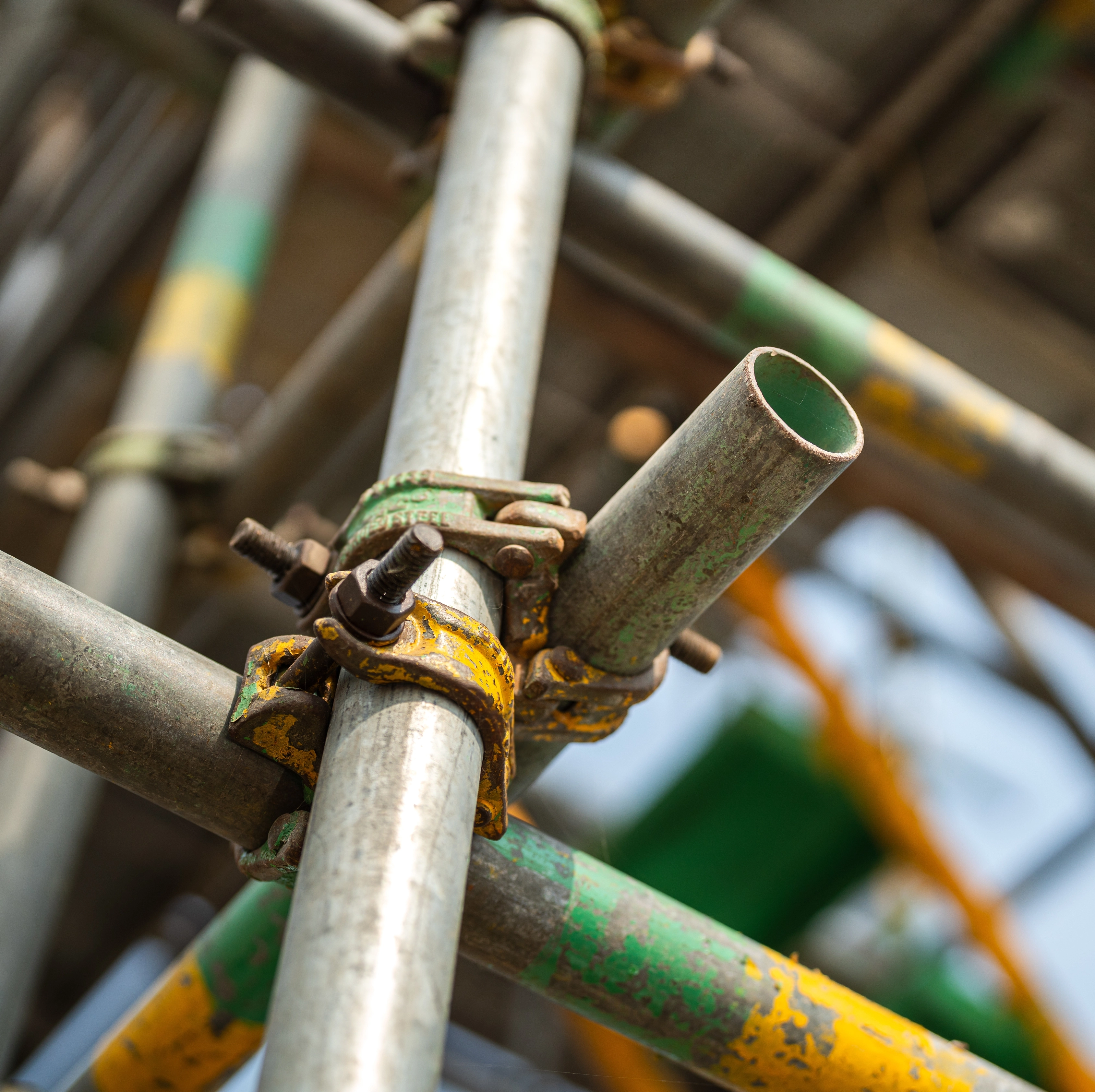 Close-up of scaffolding tubes joined by rusted clamps